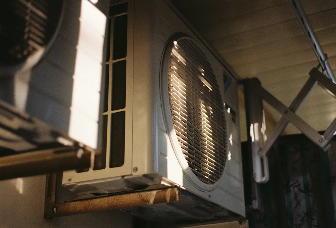 Close up of an air conditioning condenser unit in direct summer sunlight