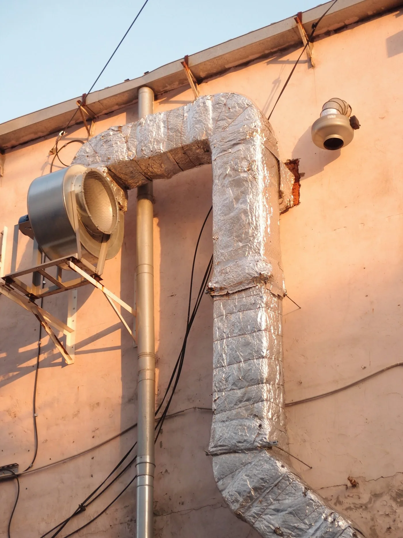 HVAC ventilation pipe running up a building exterior