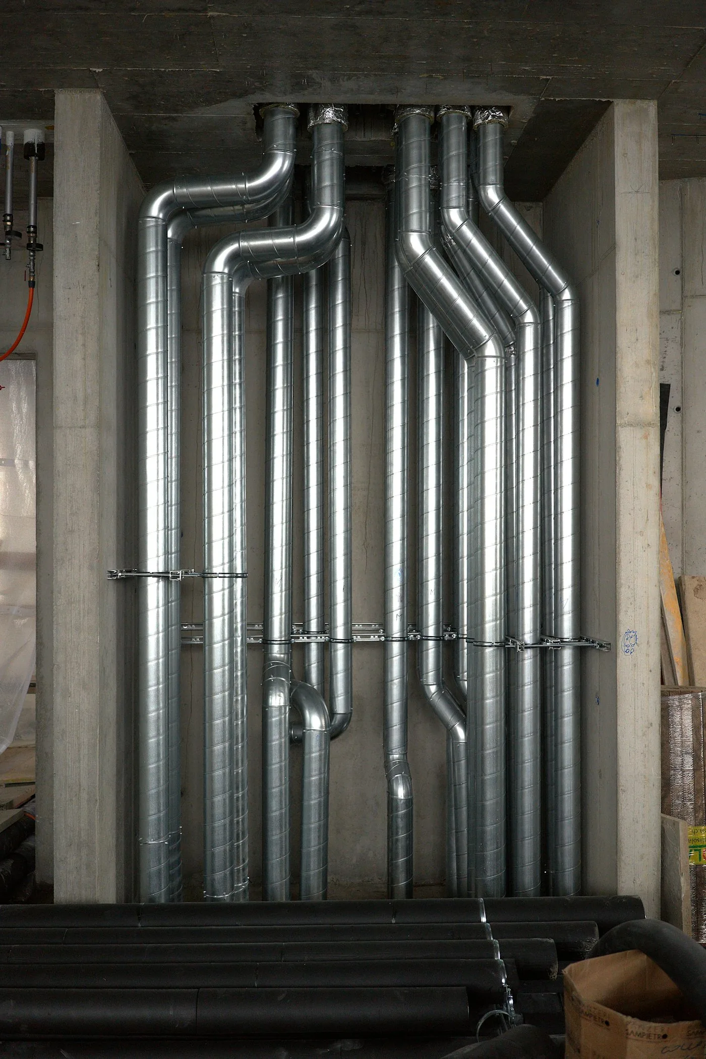 HVAC ductwork and heating pipes running through a building interior