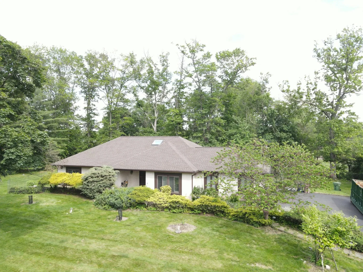 Residential house and roofline on a grassy hillside