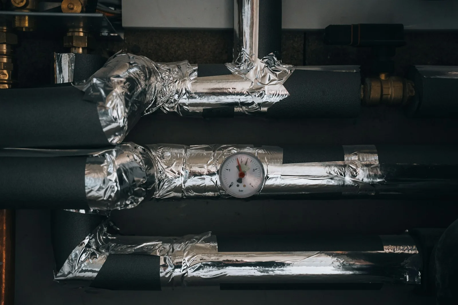 Pipework and heating equipment mounted on the wall of a mechanical room