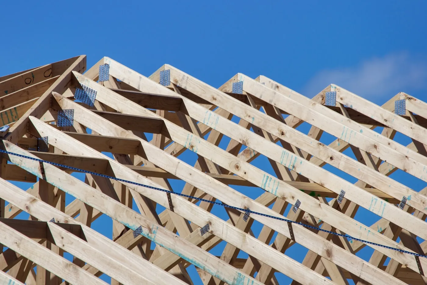 Timber roof truss structure against an open sky