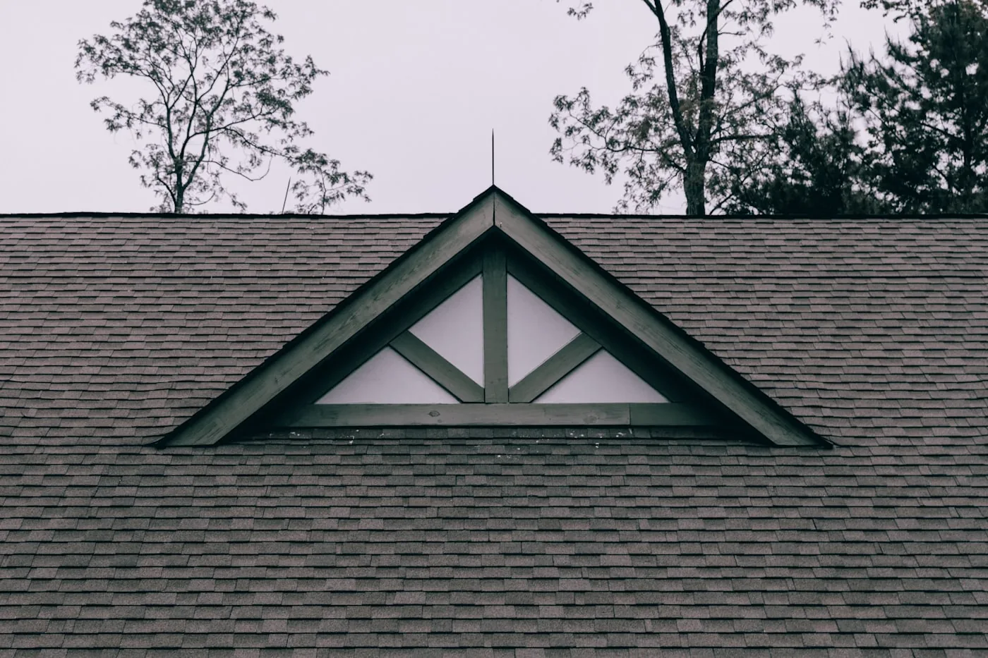 Roof gable and dormer window detail on a shingled residential roof