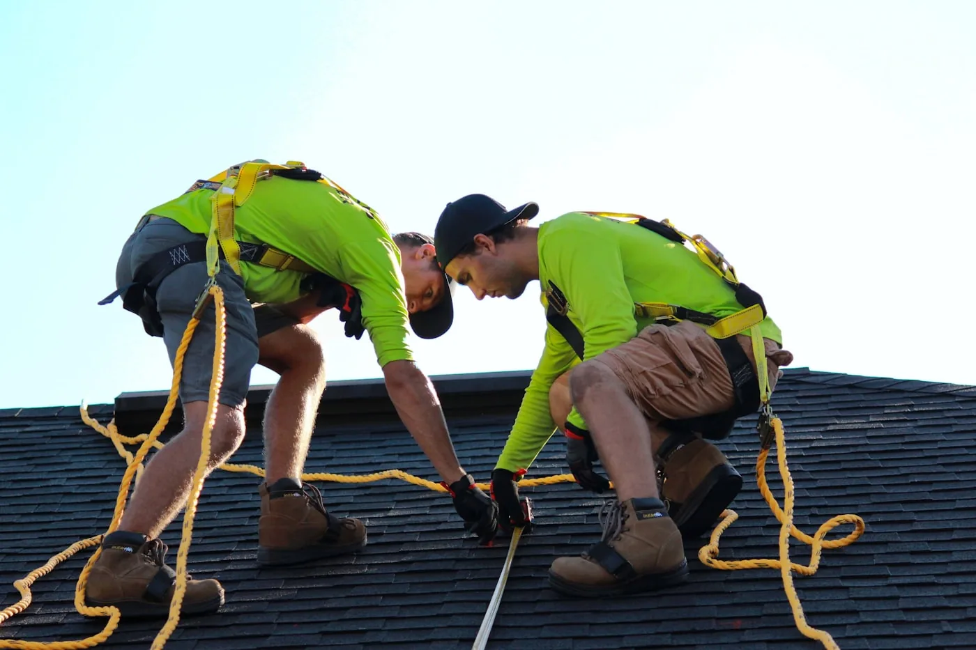 Two roofing contractors installing a new roof on a house