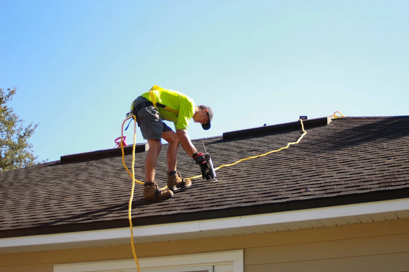 Roofing contractor using a power drill during a roof installation