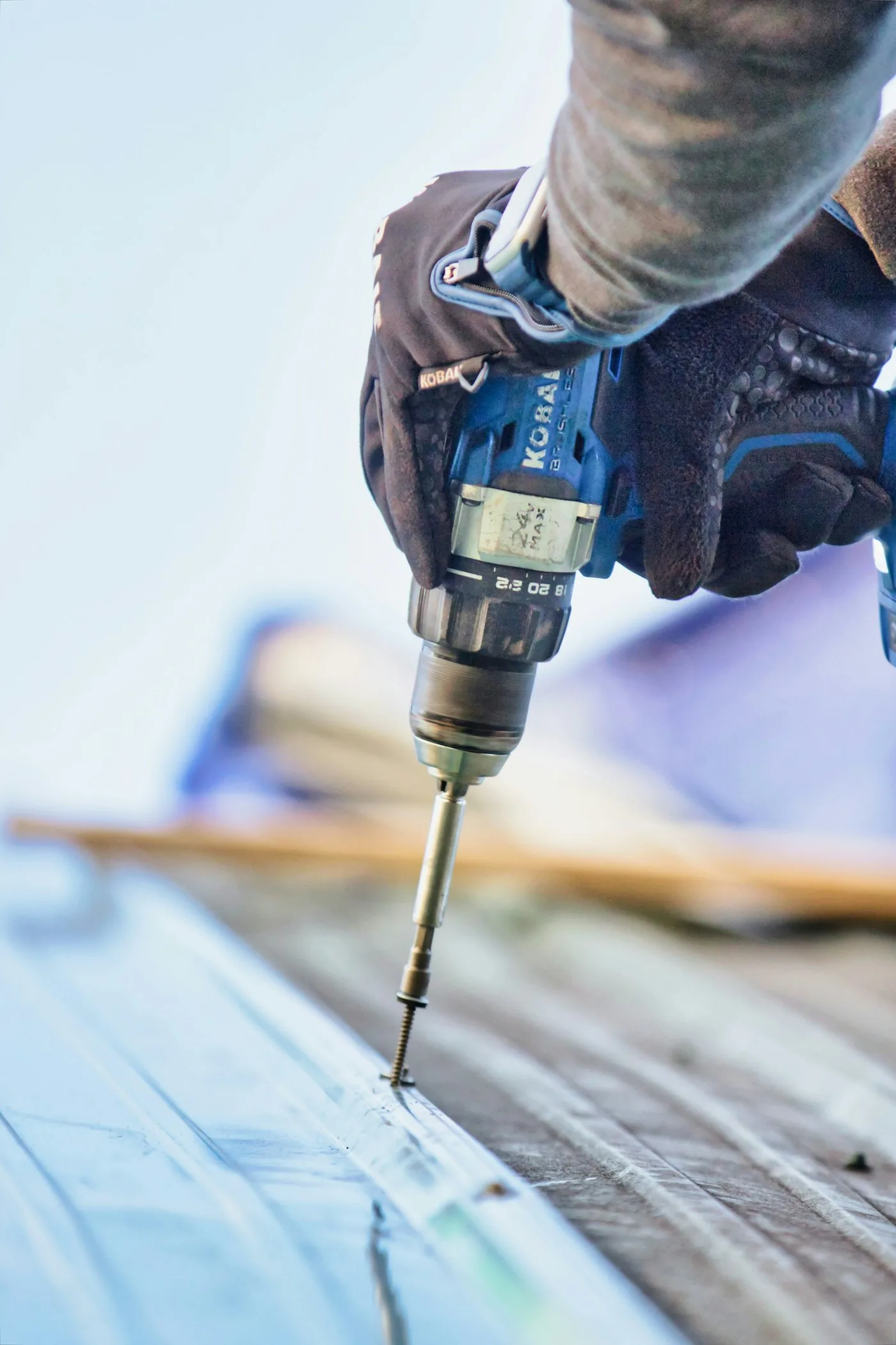 Roofer fastening timber roof decking during a re-roof